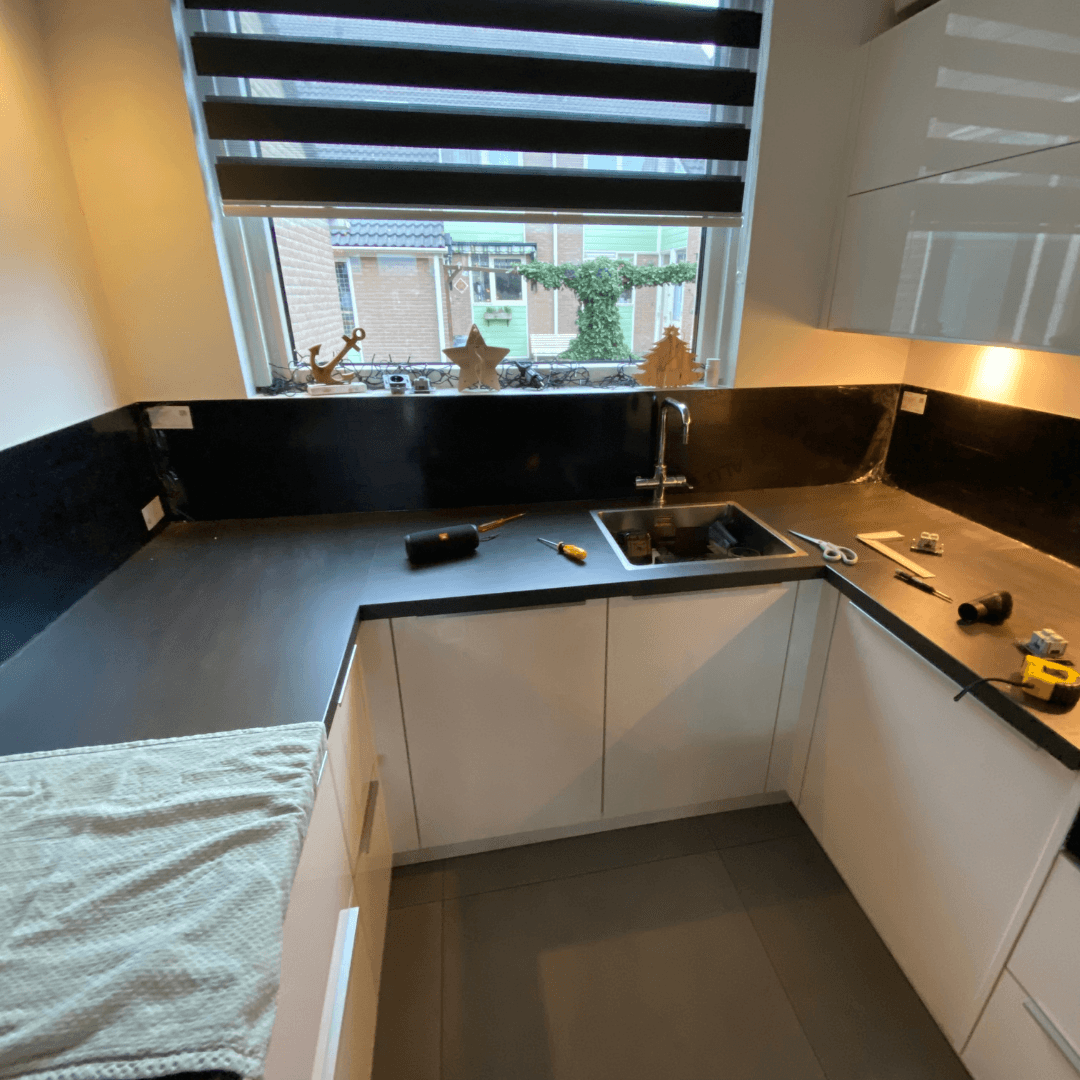Keuken achterwand van zwart geborsteld alupanel