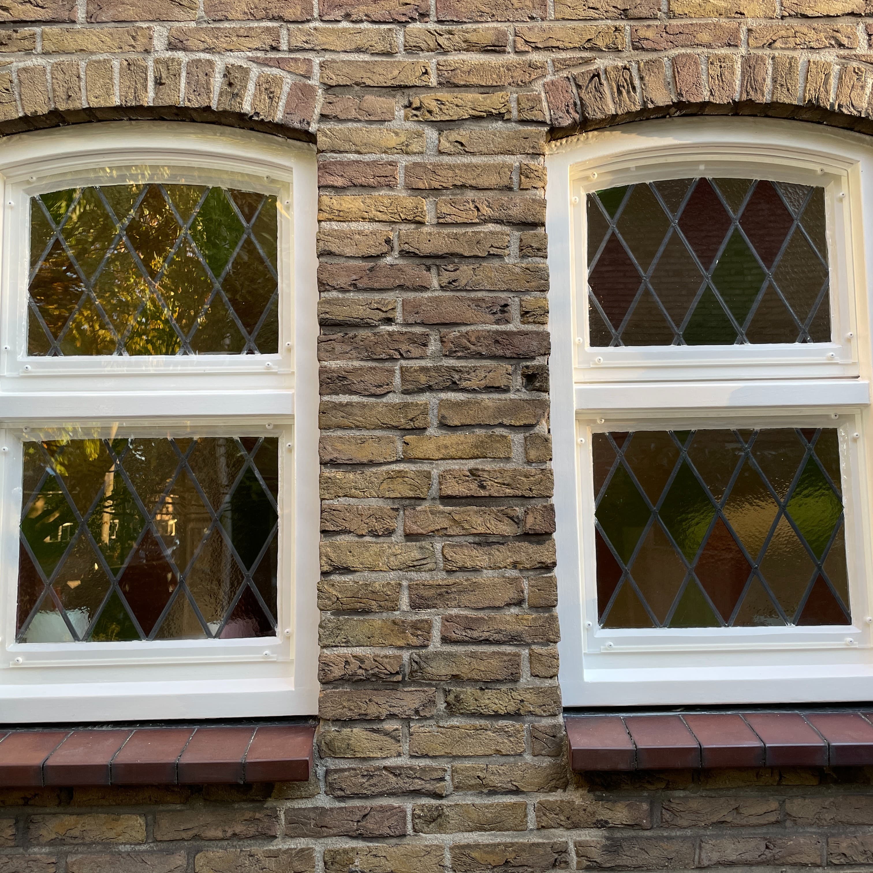 Voorzetraam aan de buitenzijde van glas-in-loodraam