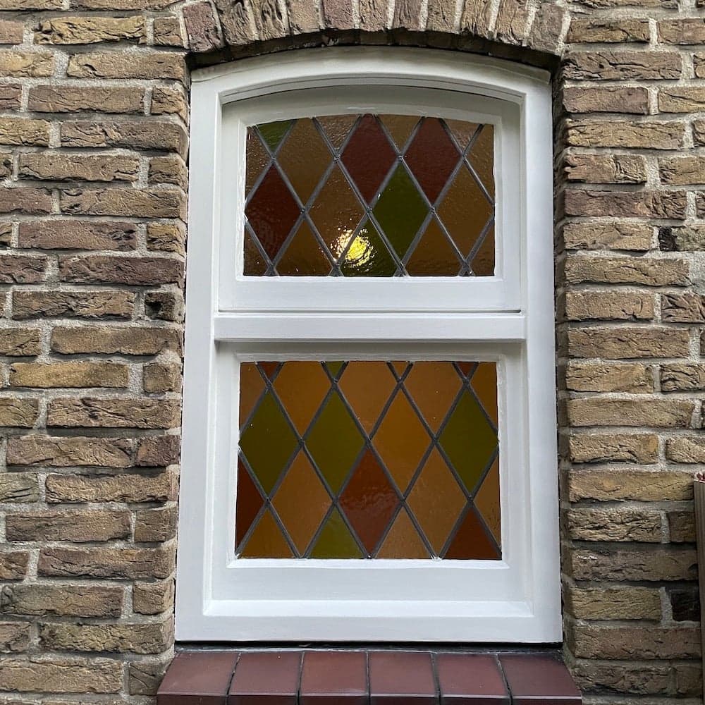 Voorzetraam aan de buitenzijde van glas-in-loodraam