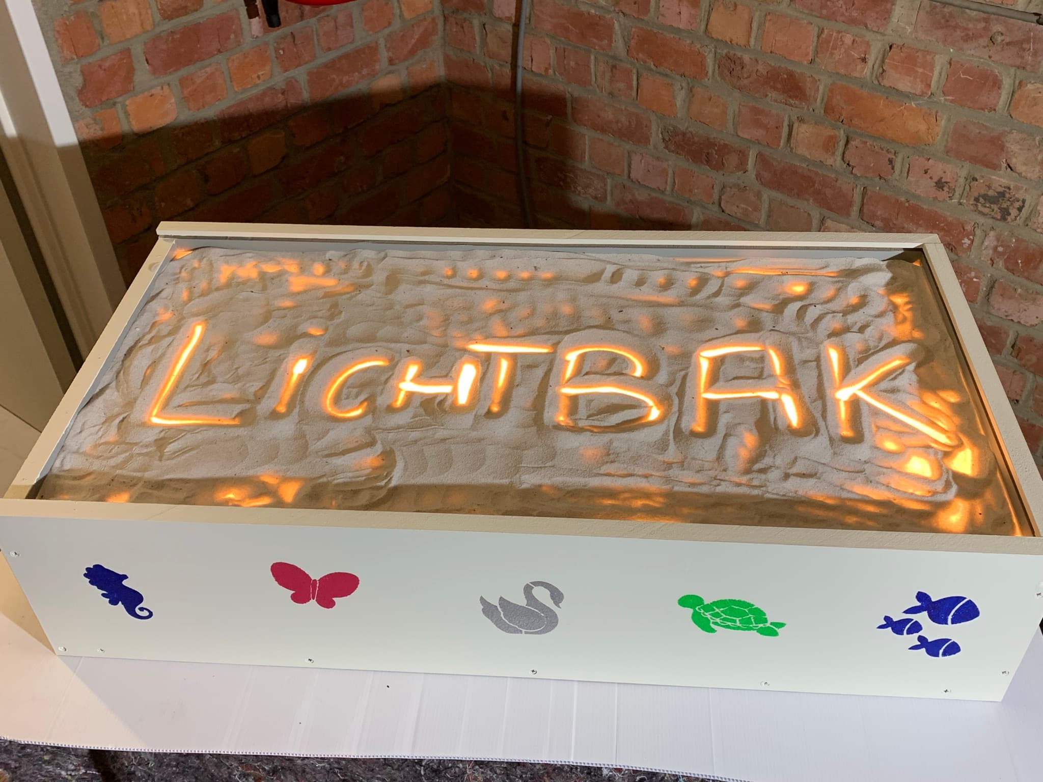 Lichtbak met zand van plexiglas