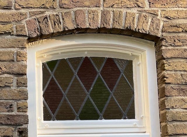 Voorzetraam aan de buitenzijde van glas-in-loodraam